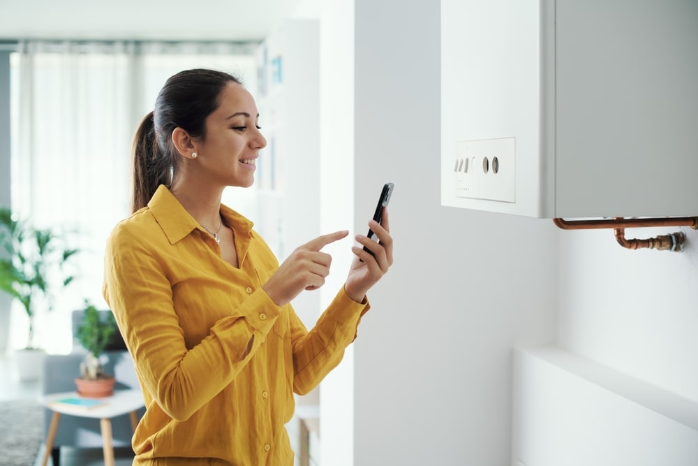 Woman using her smart control for her boiler on her phone