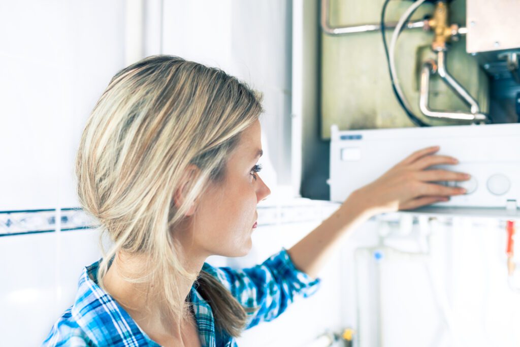 A woman inspects a household boiler during a check up